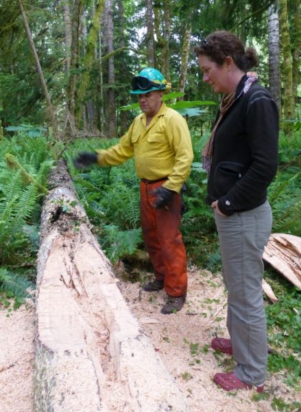 Tim Brown shows Tara Chestnut, a landowner, how he is turning a recently downed log into a home for wildlife.